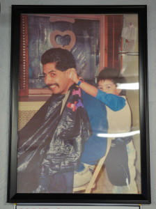 A photo of Manny Fresko Lopez cutting his father's hair back in the 90s hangs inside the barbershop.